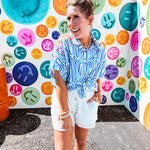 White shorts with lining and textured outer layer with elastic drawstring waist with wooden ends on the ties.