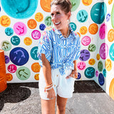 White shorts with lining and textured outer layer with elastic drawstring waist with wooden ends on the ties.