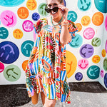 This tropical print short dress features vibrant summer hues with playful striping and fruit motifs throughout, square smocked neckline and flutter sleeves and pockets—complete with pink and blue ball tassels. Crafted from soft, lightweight fabric, it's designed to move with you all day long.