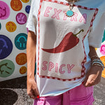 Washed white tee with pink and red checkered graphic paired with a fiery pepper design.