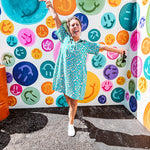 Teal and tan patterned mini dress with 1/4 button front and collar with short sleeves and pockets, fully lined.