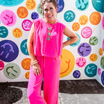 Fuchsia set including a bubble hem, sleeveless blouse with pleated shoulders and wide-leg pants with pockets.