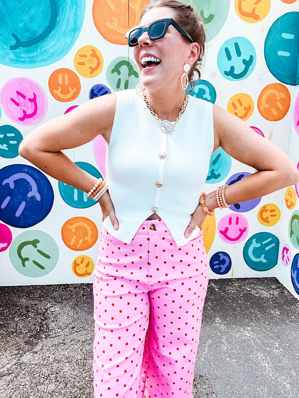 Soft, chic white button vest with gold shell and sun faux buttons down the front and a peekaboo front hem, round neck.