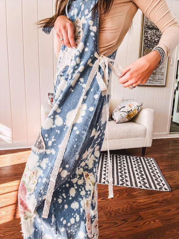 Denim patchwork overalls with tied adjustable straps, lace tied sides and floral and butterfly patches throughout.