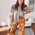 Dark mustard denim stretch pants with vintage floral print, button zipper closure, wide leg and raw hem.