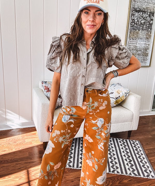 Dark mustard denim stretch pants with vintage floral print, button zipper closure, wide leg and raw hem.