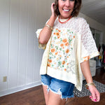 Cream lace crochet dolman style tee with orange and green floral patch and trim. Oversized.