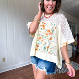 Cream lace crochet dolman style tee with orange and green floral patch and trim. Oversized.