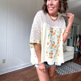 Cream lace crochet dolman style tee with orange and green floral patch and trim. Oversized.