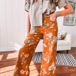 Dark mustard denim stretch pants with vintage floral print, button zipper closure, wide leg and raw hem.