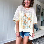 Cream lace crochet dolman style tee with orange and green floral patch and trim. Oversized.