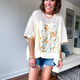 Cream lace crochet dolman style tee with orange and green floral patch and trim. Oversized.