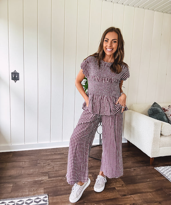 Plum and white gingham set with round neck top with smocking detail throughout and scalloped short sleeves and elastic waist wide leg pants with scalloped hem.