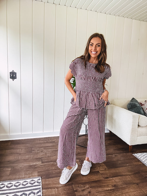 Plum and white gingham set with round neck top with smocking detail throughout and scalloped short sleeves and elastic waist wide leg pants with scalloped hem.