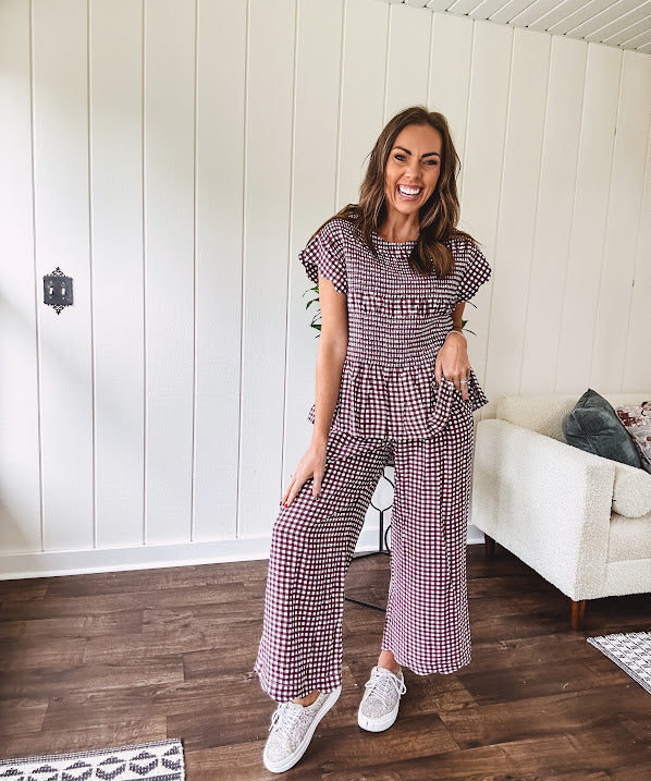 Plum and white gingham set with round neck top with smocking detail throughout and scalloped short sleeves and elastic waist wide leg pants with scalloped hem.