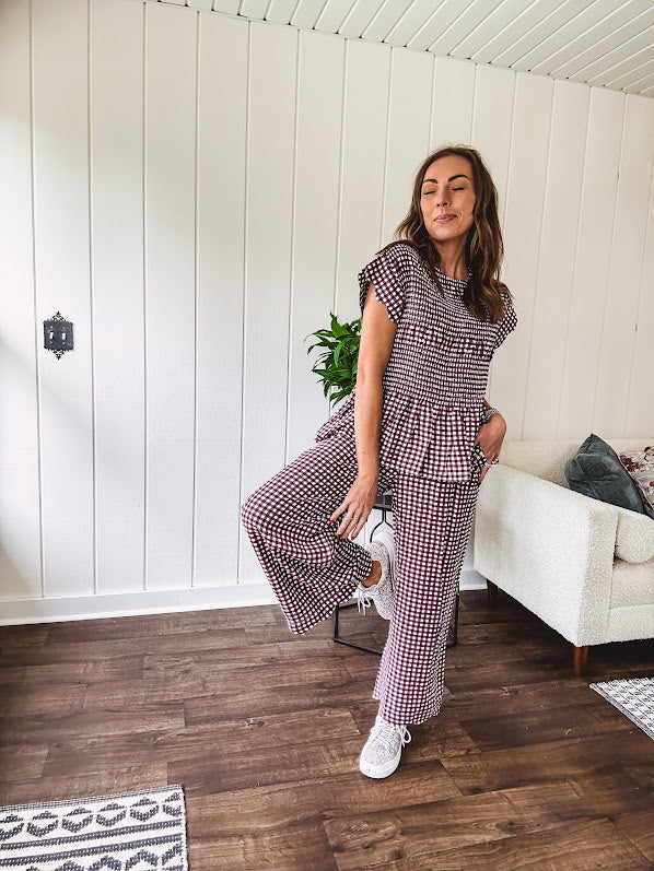 Plum and white gingham set with round neck top with smocking detail throughout and scalloped short sleeves and elastic waist wide leg pants with scalloped hem.