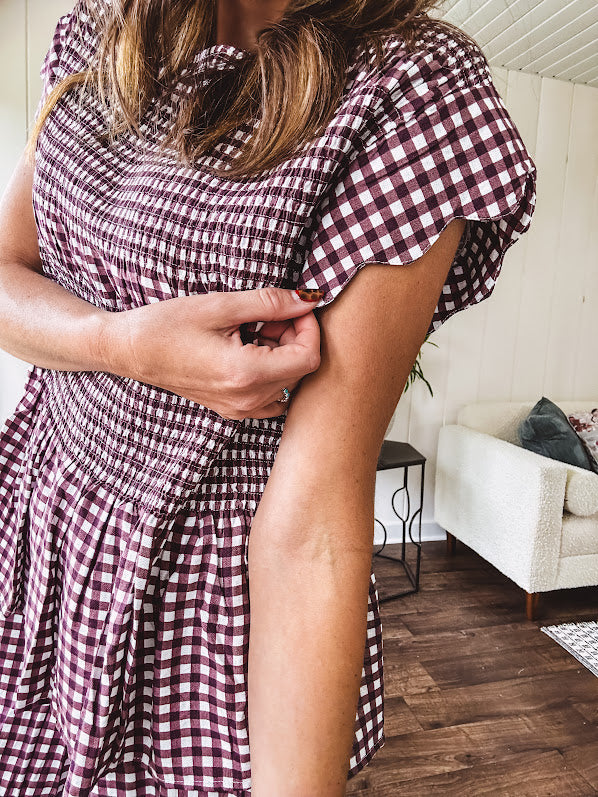 Plum and white gingham set with round neck top with smocking detail throughout and scalloped short sleeves and elastic waist wide leg pants with scalloped hem.