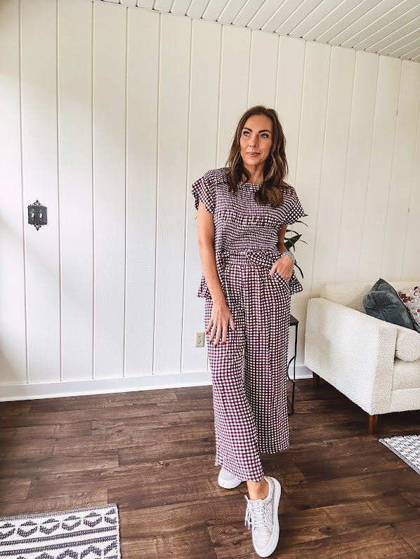 Plum and white gingham set with round neck top with smocking detail throughout and scalloped short sleeves and elastic waist wide leg pants with scalloped hem.