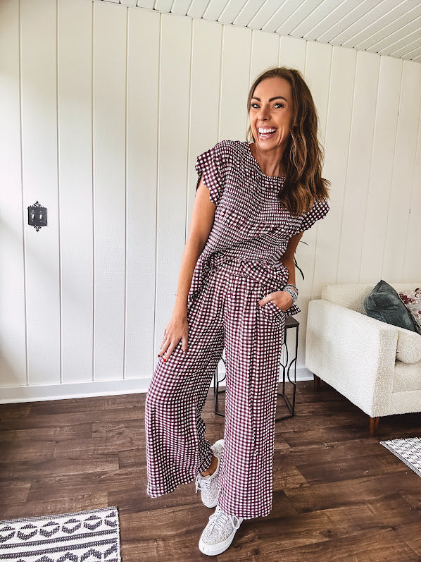Plum and white gingham set with round neck top with smocking detail throughout and scalloped short sleeves and elastic waist wide leg pants with scalloped hem.