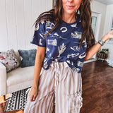 Navy short sleeved cotton top with ivory western motif print, waist length, cuffed sleeves.