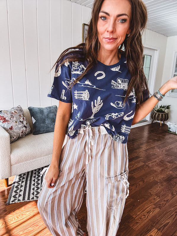 Navy short sleeved cotton top with ivory western motif print, waist length, cuffed sleeves.