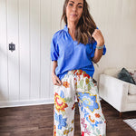 Textured ocean blue puff sleeve top with scalloped hem and mock neck with V neck front.