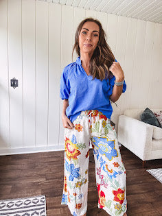 Textured ocean blue puff sleeve top with scalloped hem and mock neck with V neck front.