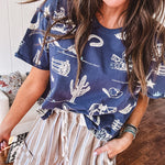 Navy short sleeved cotton top with ivory western motif print, waist length, cuffed sleeves.