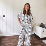 Lightweight white or black short sleeved top with black or white polka dots throughout with V neck, short ruffled sleeves and ruffled hem.