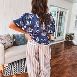 Navy short sleeved cotton top with ivory western motif print, waist length, cuffed sleeves.