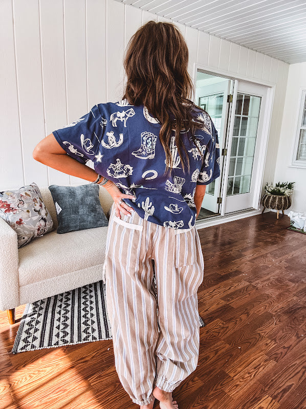 Navy short sleeved cotton top with ivory western motif print, waist length, cuffed sleeves.