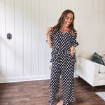 Lightweight white or black short sleeved top with black or white polka dots throughout with V neck, short ruffled sleeves and ruffled hem.