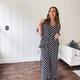 Lightweight white or black short sleeved top with black or white polka dots throughout with V neck, short ruffled sleeves and ruffled hem.