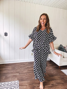 Lightweight white or black short sleeved top with black or white polka dots throughout with V neck, short ruffled sleeves and ruffled hem.