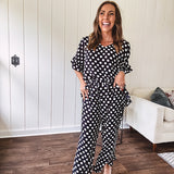 Lightweight white or black short sleeved top with black or white polka dots throughout with V neck, short ruffled sleeves and ruffled hem.