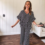 Lightweight white or black short sleeved top with black or white polka dots throughout with V neck, short ruffled sleeves and ruffled hem.