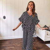 Lightweight white or black short sleeved top with black or white polka dots throughout with V neck, short ruffled sleeves and ruffled hem.