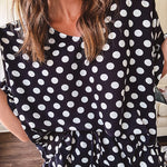 Lightweight white or black short sleeved top with black or white polka dots throughout with V neck, short ruffled sleeves and ruffled hem.