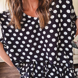 Lightweight white or black short sleeved top with black or white polka dots throughout with V neck, short ruffled sleeves and ruffled hem.