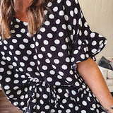 Lightweight white or black short sleeved top with black or white polka dots throughout with V neck, short ruffled sleeves and ruffled hem.