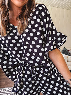 Lightweight white or black short sleeved top with black or white polka dots throughout with V neck, short ruffled sleeves and ruffled hem.