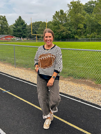 Soft, terry-like black and white striped half sleeve top with oversized leopard print football applique on the front, black trim at the round neck, cuffs and wide hem.