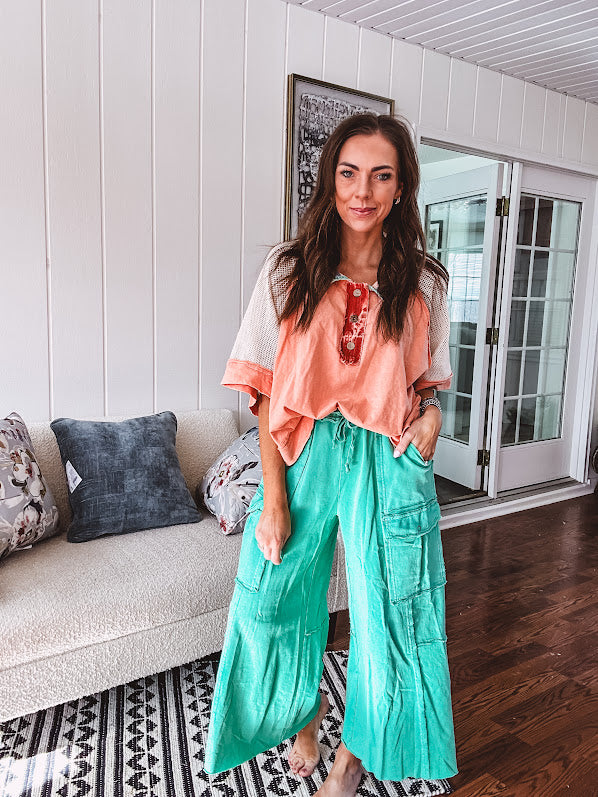 Washed teal wide leg utility pants with a raw hem and elastic drawstring waist.