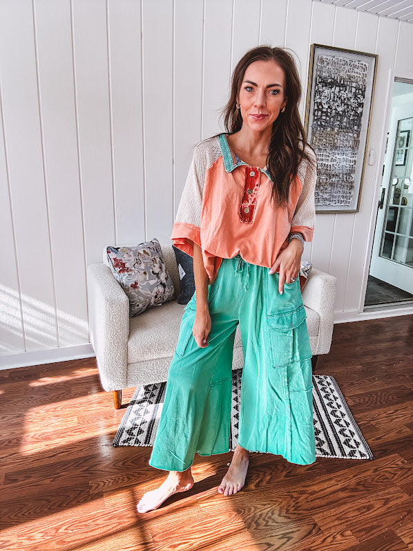 Washed teal wide leg utility pants with a raw hem and elastic drawstring waist.