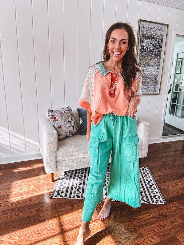 Washed teal wide leg utility pants with a raw hem and elastic drawstring waist.