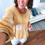 Soft, lightweight, nearly sheer knit pullover  with long sleeves, exposed seams at the shoulders and down the center with large daisy florals throughout. Available in multiple colors.