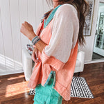 Salmon colored 3/4 sleeve blouse with striped blue and brown yarn collar, three wooden buttons on front, relaxed fit and mesh at the shoulders and sleeves.