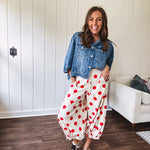Soft, stretchy cream elastic drawstring waist pants with large red polka dots throughout, pockets and button cuffs for a balloon-like silhouette.