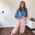 Soft, stretchy cream elastic drawstring waist pants with large red polka dots throughout, pockets and button cuffs for a balloon-like silhouette.