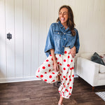 Soft, stretchy cream elastic drawstring waist pants with large red polka dots throughout, pockets and button cuffs for a balloon-like silhouette.